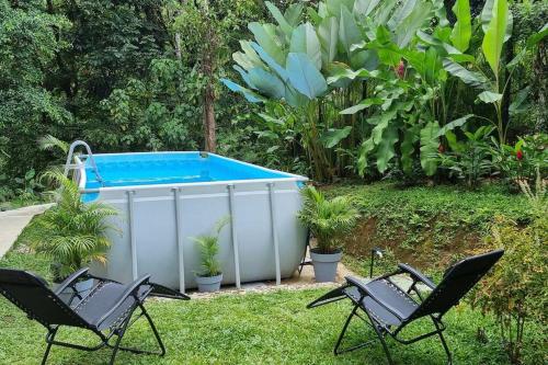 Duas cadeiras e uma banheira de hidromassagem num quintal em Villas Töcu - Casa Colibrí em La Fortuna