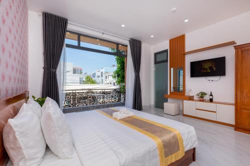 ein Schlafzimmer mit einem Bett und einem großen Fenster in der Unterkunft Villas & Hotel 126 Vũng Tàu in Vũng Tàu