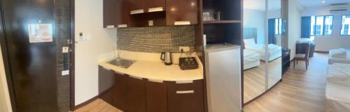 a kitchen with a sink and a refrigerator in a room at Deluxe Twin Room AYS in Kota Kinabalu