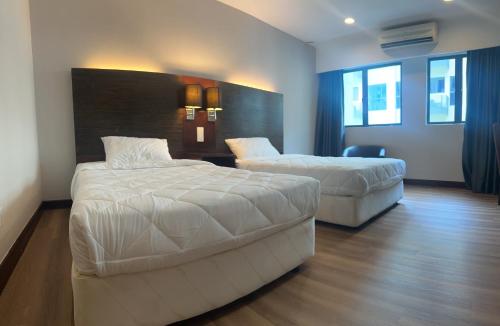 a hotel room with two beds and a chair at Deluxe Twin Room AYS in Kota Kinabalu