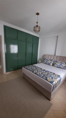 um quarto com uma cama com armários verdes em magnifique appartement em Tânger