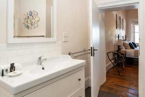 a white bathroom with a sink and a room at Surgeon's Cottage in Morpeth