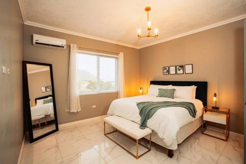a bedroom with a bed and a mirror and a chair at Lush Penthouse Escape with Rooftop Pool in Kingston