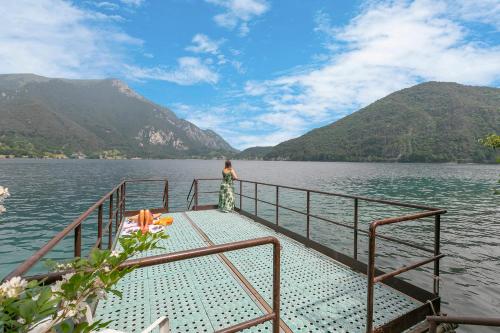 Una donna sul ponte di una barca su un lago di Casa Paola al Lago - Happy Rentals a Ledro