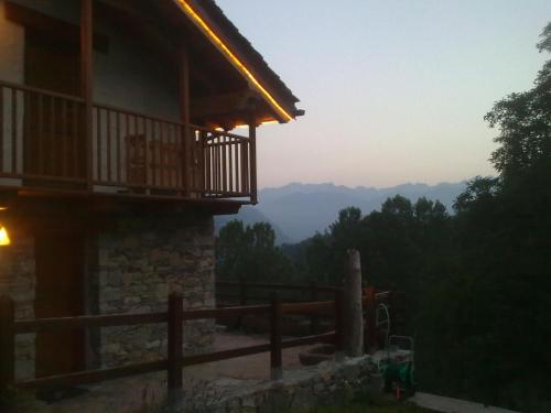 a house with a balcony and a view of the mountains at Eco Chalet Maison Dominique in Challand Saint Anselme