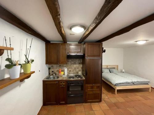 kuchnia z kuchenką i łóżko w pokoju w obiekcie Creek’s cave studio - The paradise for climbers w mieście Arcegno