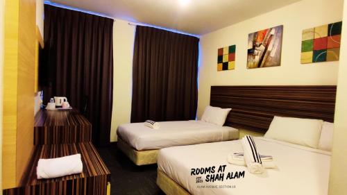 um quarto de hotel com duas camas num quarto em Rooms at Hotel Shah Alam em Shah Alam
