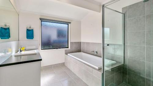a bathroom with a shower and a sink and a tub at Island Holidayze in Cowes