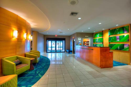 a lobby of a hotel with green chairs and a bar at SpringHill Suites by Marriott - Tampa Brandon in Tampa