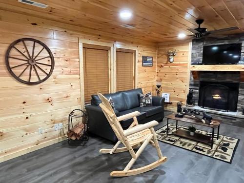 a living room with a black couch and a fireplace at Paradise at the Smokies Cabin in Sevierville