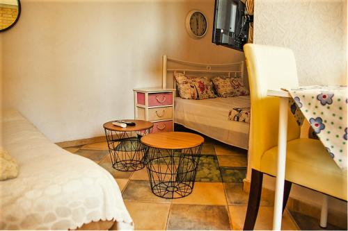 um pequeno quarto com uma cama e duas mesas em sea view center studio em Tessalônica