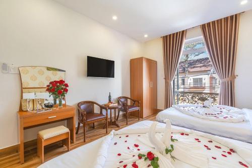una camera d'albergo con due letti e una televisione di Villa Hoa Ly Đà Lạt a Da Lat