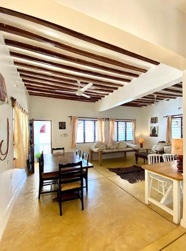 Beautiful Mafriza Apartment في لامو: غرفة معيشة كبيرة مع طاولة وكراسي
