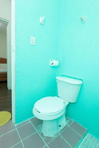a bathroom with a toilet in a blue wall at Casa Blanca in Santa Cruz Huatulco