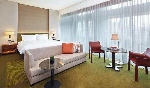 a hotel room with a bed and a couch at Eslite Hotel in Taipei