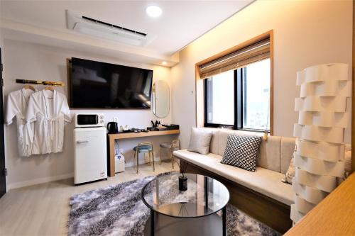 salon z kanapą i telewizorem w obiekcie De Lamour Hotel w mieście Tongyeong