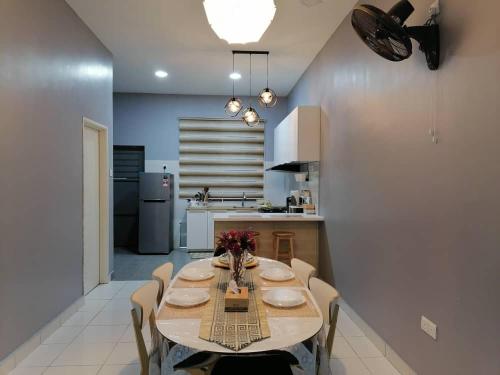 a dining room with a table and chairs in a kitchen at DKAMAR Homestay At Desaru, IKEA Concept, Wifi, 3 Airconds, Nearby Desaru Beach in Bandar Penawar