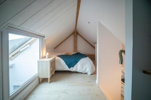 a attic bedroom with a bed and a window at Appart'Hôtel & Spa "Les Voiles" Le Houat in Carnac