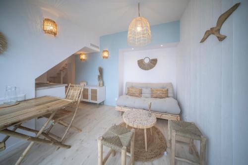 a living room with a couch and a table at Appart'Hôtel & Spa "Les Voiles" Le Houat in Carnac