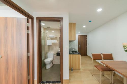 a bathroom with a toilet and a kitchen with a table at GoldCoast Hotel Nha Trang in Nha Trang