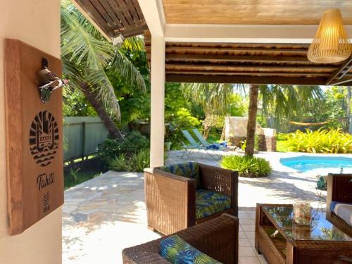 a patio with chairs and a table and a pool at Villa Hoama Lodge Moorea in Teavaro