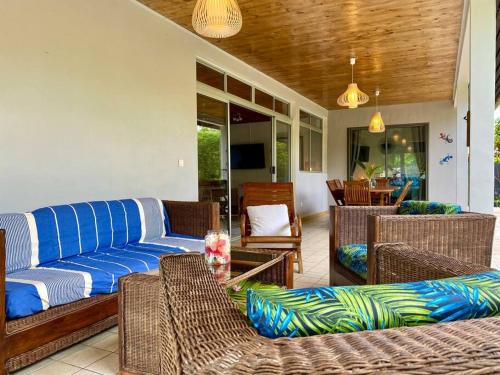 a living room with a blue couch and chairs at Villa Hoama Lodge Moorea in Teavaro