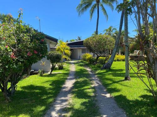 a house with palm trees and a dirt road at Villa Hoama Lodge Moorea in Teavaro