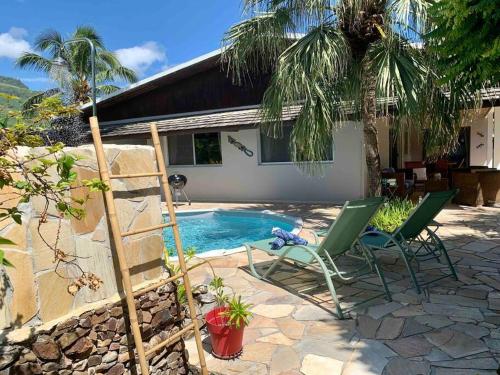 a patio with two chairs and a swimming pool at Villa Hoama Lodge Moorea in Teavaro