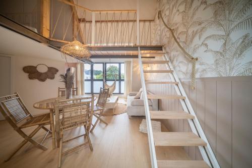 - un escalier dans une pièce avec une table et des chaises dans l'établissement Les Voiles - Appart'hotel "Le Molène", à Carnac