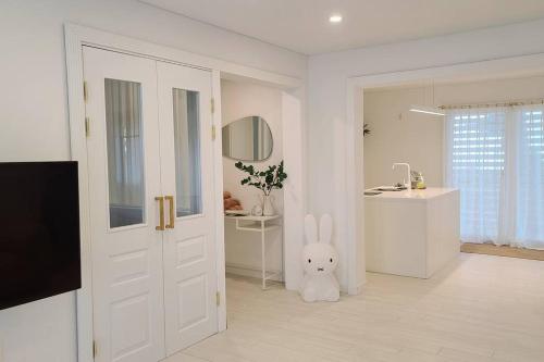 a white room with a white door and a stuffed bunny at Jeju Polaris Pension in Jeju