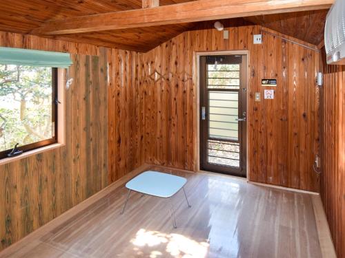 een kamer met houten lambrisering en een deur bij Tonosaki Bungalow & BBQ - Vacation STAY 29542v in Tsushima