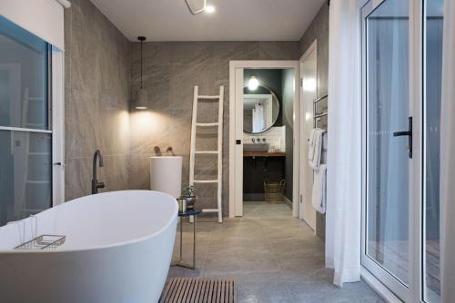 a bathroom with a white tub and a sink at The Arlow House in Daylesford