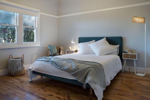 a bedroom with a large bed and two windows at The Arlow House in Daylesford