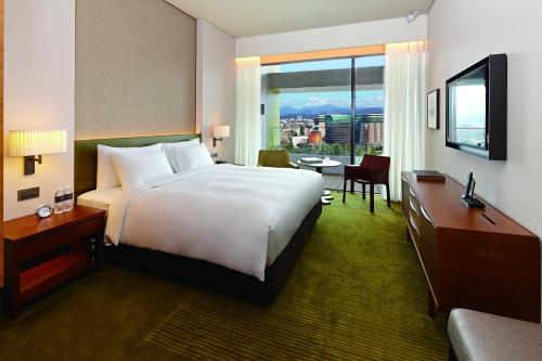 a hotel room with a large bed and a television at Eslite Hotel in Taipei