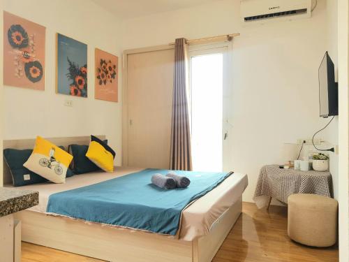 a bedroom with a bed with blue sheets and a window at Libré Homestay in Hanoi