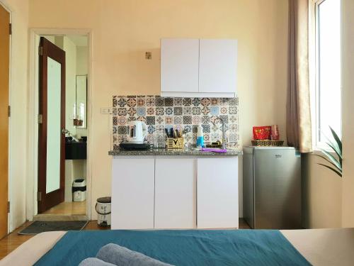 a kitchen with white cabinets and a refrigerator at Libré Homestay in Hanoi
