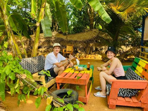 Ein Mann und eine Frau sitzen an einem Tisch in der Unterkunft Reggae paradise hostel in Sigiriya