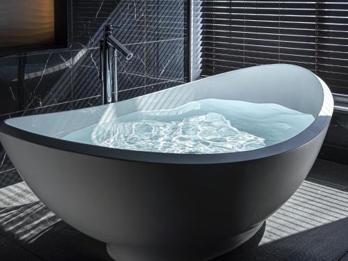 a bath tub filled with water in a bathroom at Villa Fontaine Premier Haneda Airport in Tokyo