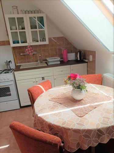 a kitchen with a table with a vase of flowers on it at Vendégház a Csabay Kúriához in Lakitelek
