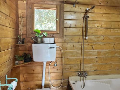 a wooden bathroom with a toilet and a shower at הבלוט - בקתה אינטימית בצל אלון in Abirim