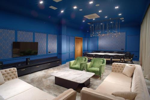 a living room with blue walls and a dining room at NEOS HOTEL in Astana
