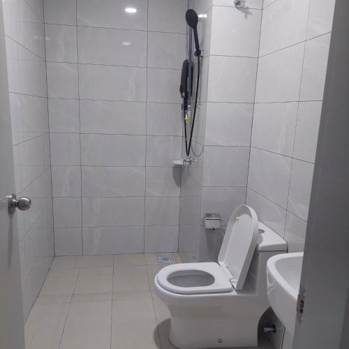 a white bathroom with a toilet and a sink at Amber cove in Malacca