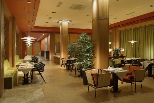 a restaurant with tables and chairs and a cafeteria at NEOS HOTEL in Astana