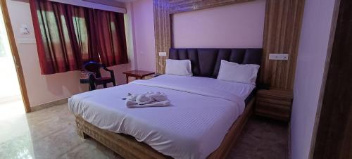 Un dormitorio con una cama con una toalla. en Hotel Vedant en Port Blair