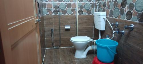 a bathroom with a toilet and a shower stall at Hotel Vedant in Port Blair