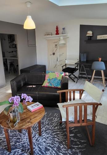 un salon avec un canapé noir et une table dans l'établissement pour vos séjours pro ou détentes, à Issoire