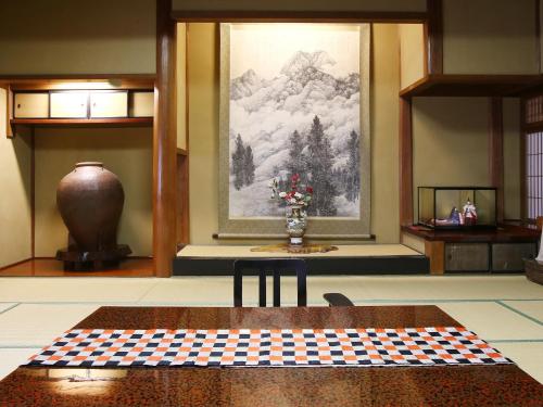 a room with a table and a painting on the wall at Kisoji no Yado Iwaya in Kiso