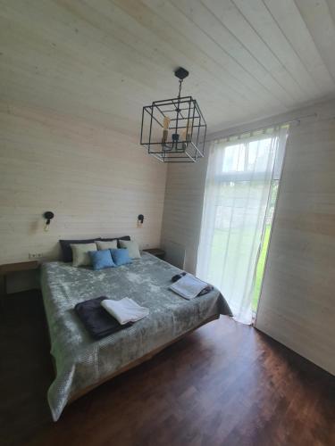 a bedroom with a large bed and a chandelier at Holiday House "Sea Nest" in Kalni