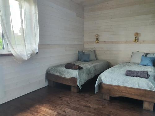 two twin beds in a room with white walls at Holiday House "Sea Nest" in Kalni