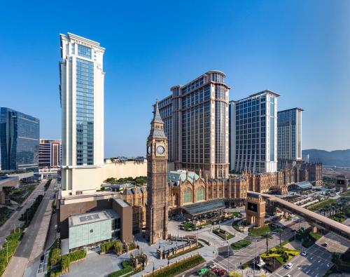 uma cidade com uma torre de relógio em frente a edifícios altos em St. Regis Macao em Macau